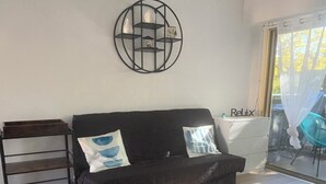 Ein modernes Wohnzimmer mit einer schwarzen Couch, einem weißen Couchtisch und einer schwarzen Metallregaleinheit.