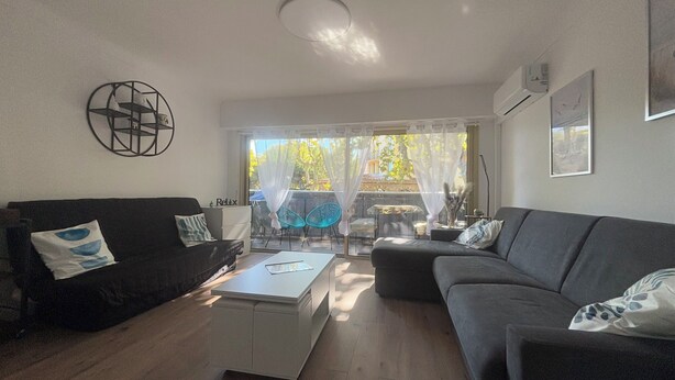 Ein Wohnzimmer mit einer Couch, einem Couchtisch und einem Essbereich mit Stühlen und einem Tisch.