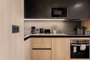 Apartamento standard, sacada | Cozinha privada | Geladeira, micro-ondas, fogão, cooktop