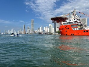 Un horizonte urbano con un barco rojo grande amarrado en un muelle.
