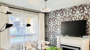 Uma sala de estar moderna com sofá, televisão e lareira.
