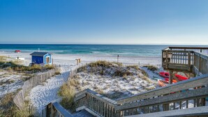 Een strand met houten looppaden en een redderpost.