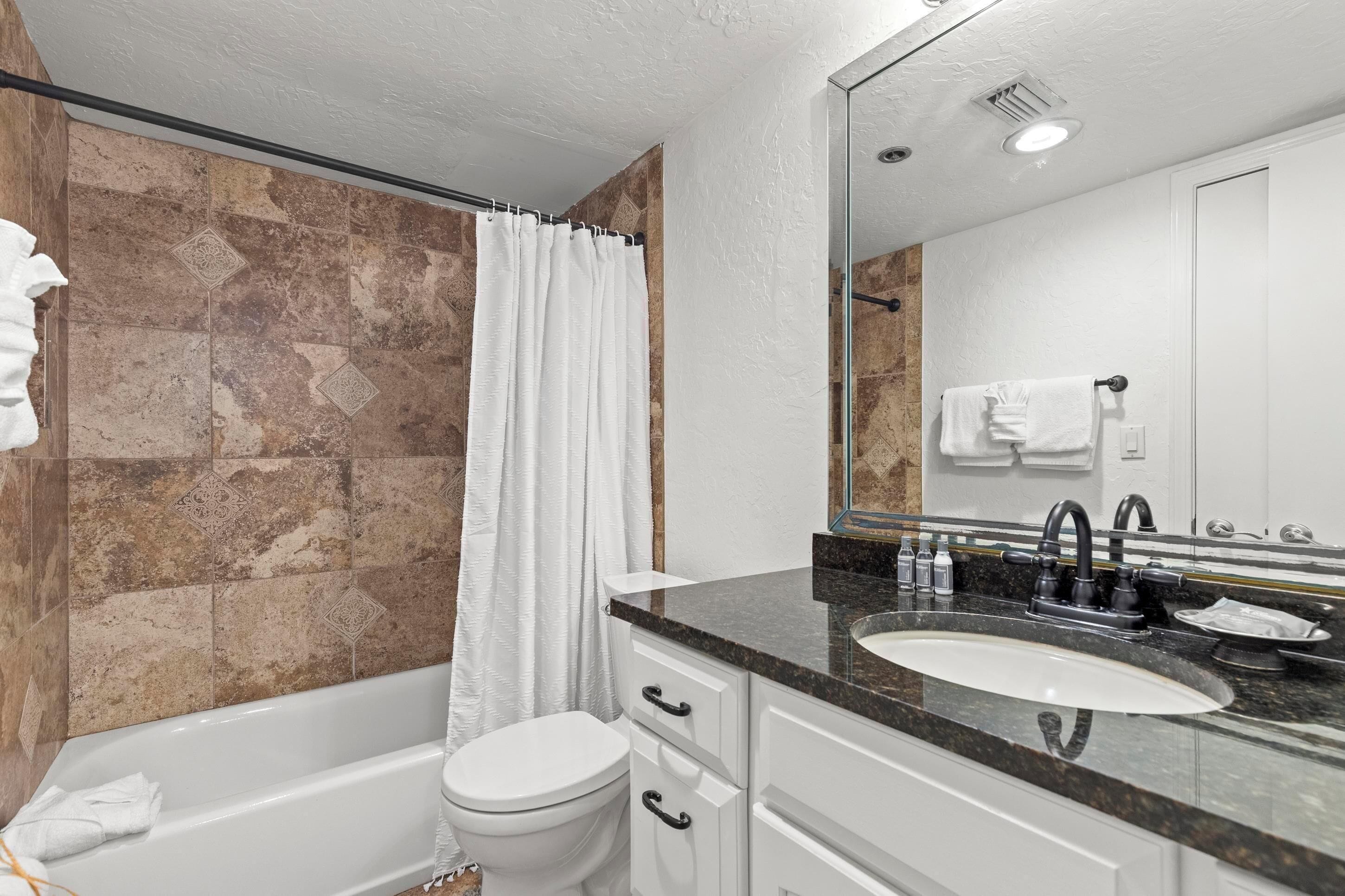 Un bagno moderno con vasca, water e lavandino.