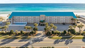 Ein Hotel mit blauem Dach, einem Pool und Blick auf den Ozean.