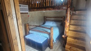 A loft bedroom with a wooden staircase, a bunk bed, and a small seating area. - Charming cabin with WIFI and AC in delightful Show Low, Az
Minimum 2 night stay. (Show Low)