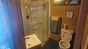 A bathroom with a shower, toilet, and sink. - Charming cabin with WIFI and AC in delightful Show Low, Az
Minimum 2 night stay. (Show Low)
