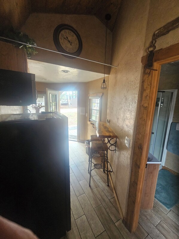 A kitchen with a wooden table, chairs, and a hanging light fixture. - Charming cabin with WIFI and AC in delightful Show Low, Az
Minimum 2 night stay. (Show Low)