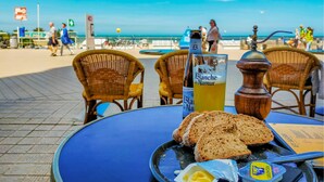Une table avec du pain, du beurre et une bouteille de vin Blanche de Narmer dans un restaurant en bord de mer.