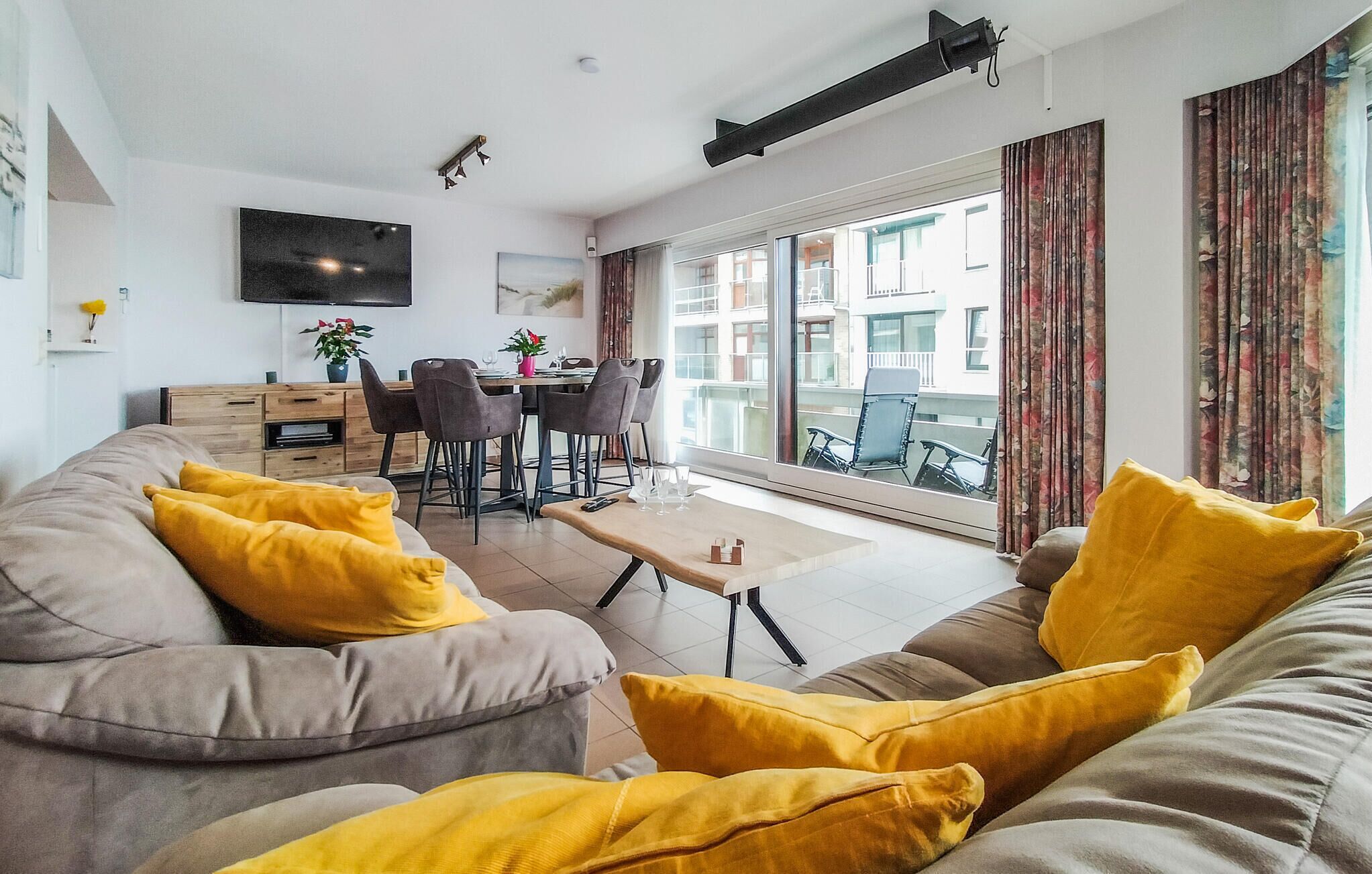 A modern living room with a sofa, coffee table, and dining area.