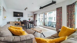 Un salon moderne avec un canapé, une table basse et un coin repas.