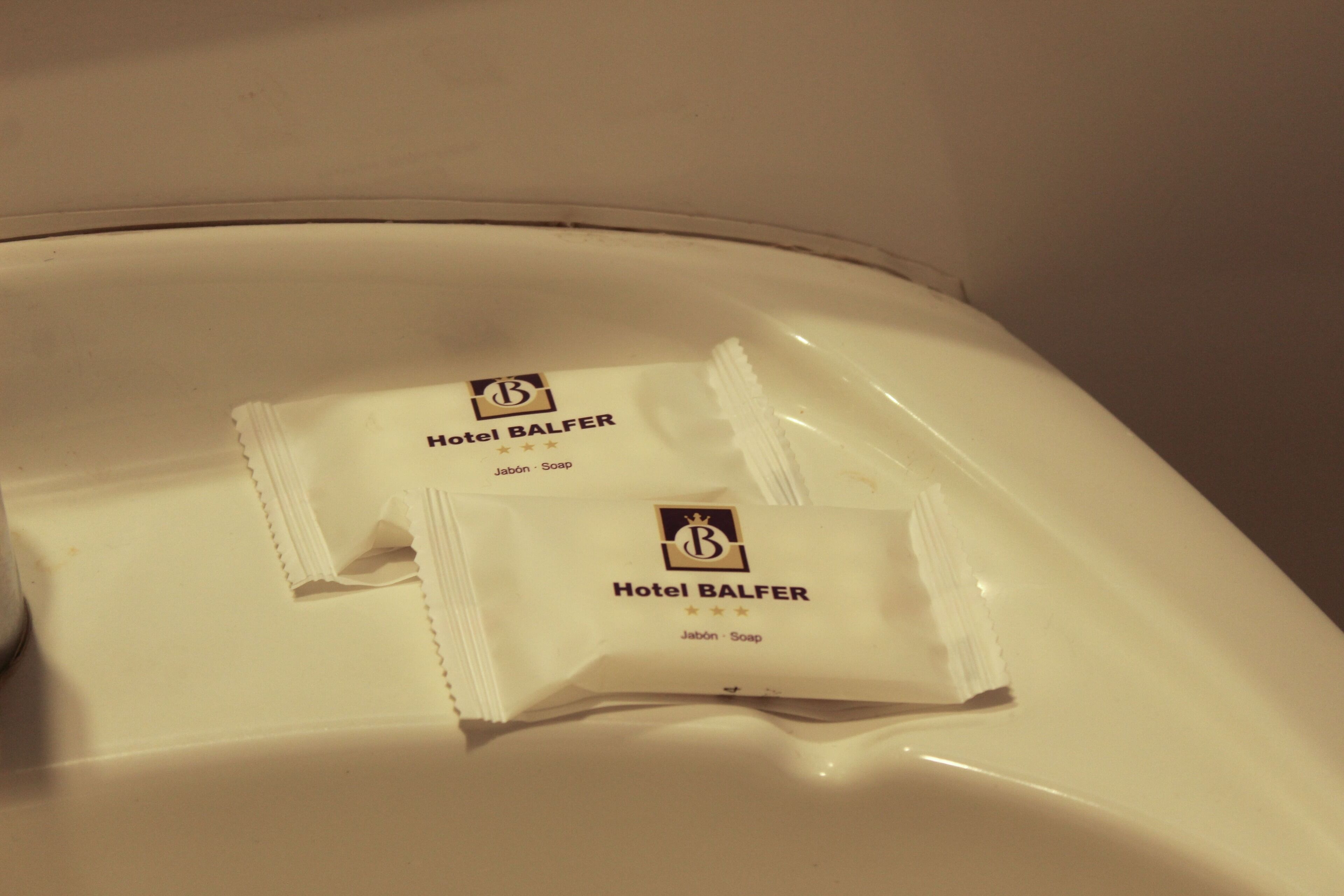 Dos paquetes de jabón Hotel Balfer sobre un lavabo blanco.