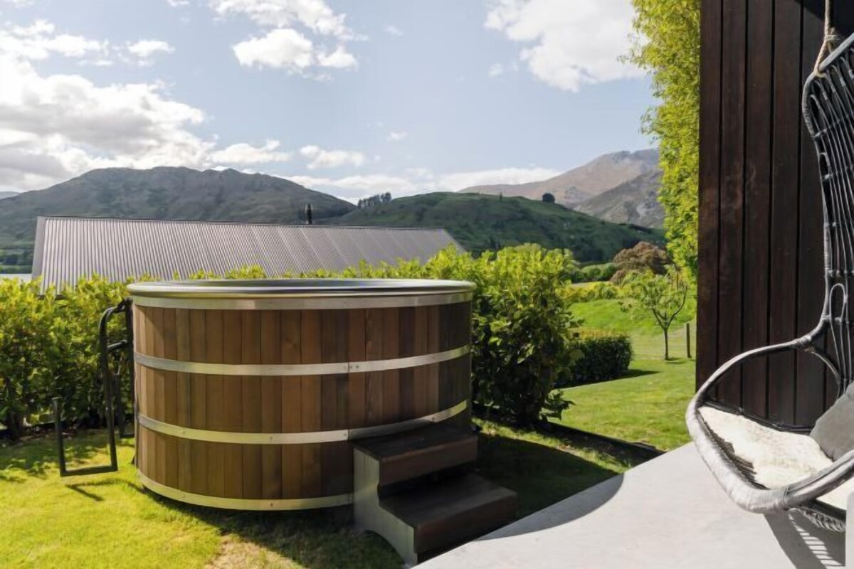 Jacuzzi con escalones, una silla y vistas a las colinas.