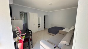 Espaço compacto com cozinha compacta, área de refeições e cama.