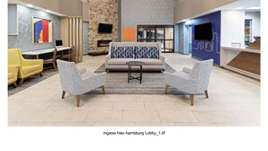 Eine großzügige Lobby mit modernem Design, inklusive einer Steinwand, einem Kamin und einer Sitzecke mit einer Couch und Sesseln.