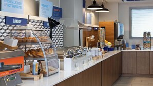 Ein Bereich für das Frühstücksbuffet mit verschiedenen Speisen und einer Bäckereiecke.