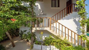 A white villa with a wooden staircase and a sign reading "BABU VILLAS". - 3 Apartment, 4-Bedroom Beach Villa Property with Private Pool Jambiani, Zanzibar (Jambiani)
