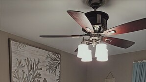 A bedroom with a bed, a ceiling fan, a framed artwork, a bedside table, and a wall decoration. - 3-bedroom townhome in beautiful North Wildwood with AC two blocks from the beach (North Wildwood)