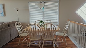 A dining area with a round table and four chairs, a ceiling light, and a window with blinds. - 3-bedroom townhome in beautiful North Wildwood with AC two blocks from the beach (North Wildwood)