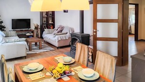 A living room with a sofa, a television, a fireplace, and a dining area set with plates, cutlery, and a fruit bowl. - Lovely apartment in Hreljin (Hreljin)