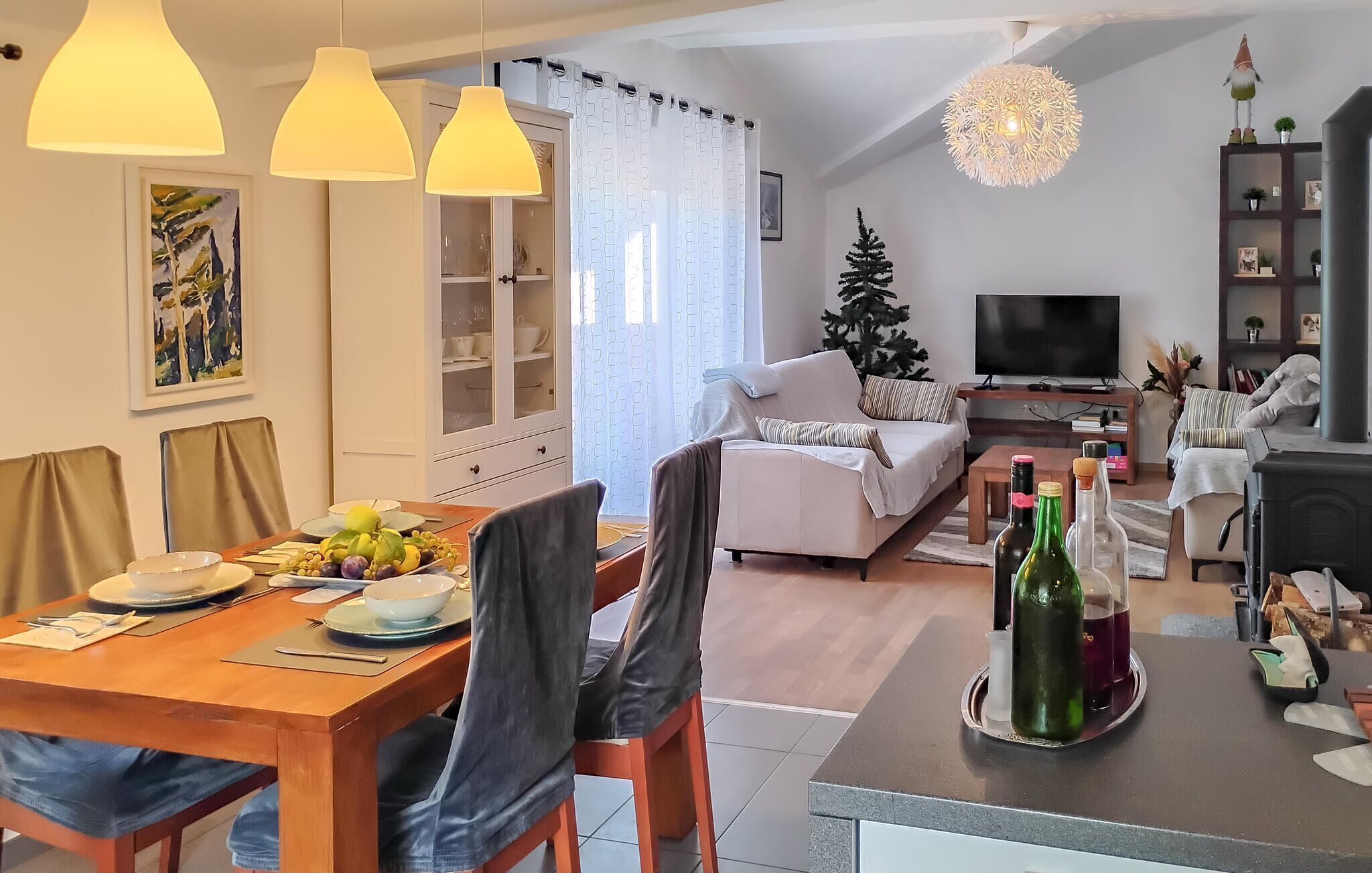 Moderni olohuone, jossa on ruokailutila, takka ja televisio.