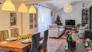 A modern living room with a dining area, a fireplace, and a television. - Lovely apartment in Hreljin (Hreljin)