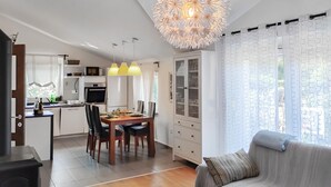 A modern kitchen with a dining area, a built-in oven, and a glass-fronted cabinet. - Lovely apartment in Hreljin (Hreljin)