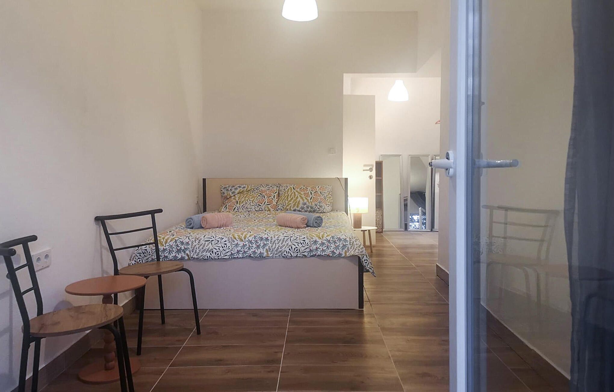 A small, modern bedroom with a bed, a chair, and a table.
