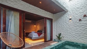 A bedroom with a bed, a chair, and a small pool. - Amana Icaraizinho (Amontada)