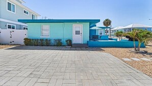 A two-story house with a light blue exterior, a front door, and a small porch area. - LOCATION!! LOCATION!!  SHORT WALKING TO RESTAURANTS, SHOPS, & BEACH! (Fort Myers Beach)