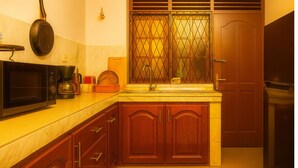 A compact kitchen with a microwave, coffee maker, and a sink.