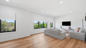 Een moderne woonkamer met een bank, een salontafel en een flatscreen-televisie.
