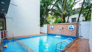 Uma piscina com um muro de tijolos e uma placa com a inscrição 'My Space'.