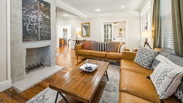 A living room with a wooden coffee table, a brown sofa, and a fireplace.