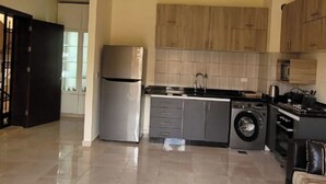Eine geräumige Küche mit Kühlschrank, Waschmaschine und moderner Schränke.