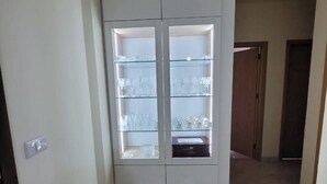 Ein Flur mit einem weißen Schrank, der Gläser und ein kleines Gerät beherbergt.
