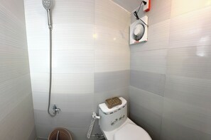 A bathroom with a shower, toilet, and a small bucket. - Monaliza Surf Resort By Zuzu (San Juan)