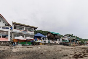 A beachfront area with buildings, including a restaurant named 'Monaliza' and a bar named 'Inke Heineken'. - Monaliza Surf Resort By Zuzu (San Juan)