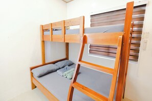 A bunk bed with a wooden frame, a window with blinds, and a small table attached to the bed. - Monaliza Surf Resort By Zuzu (San Juan)