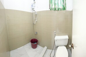 A small bathroom with a toilet, a shower, and a bucket. - Monaliza Surf Resort By Zuzu (San Juan)