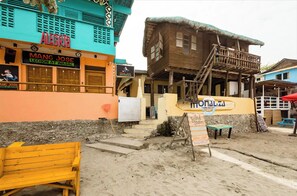 A beachside building with a sign for 'Mangal Jose Lechon at Inasal' and another for 'Monalisa Surf Beach'. - Monaliza Surf Resort By Zuzu (San Juan)