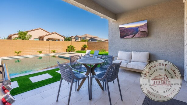 Eine Terrasse mit Pool, Gartenmöbeln und Blick auf angrenzende Häuser.