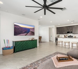 A modern kitchen with dark cabinets, a microwave, and a sink. - Private Retreat House with Pool and Spa/Hot Tub Min from Westgate, Andretti Karting, and TWoods Golf (Phoenix)