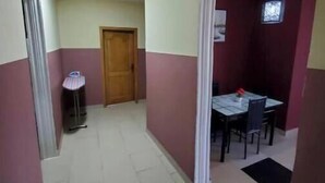 Corredor que dá para uma sala de jantar com mesa e cadeiras.