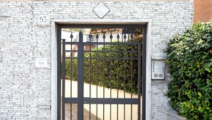 A gated entrance with a number sign, a brick wall, and a hedge. - CHARME HOLIDAYS PUCCINI (Rome)