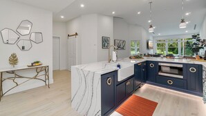 A modern kitchen with a marble island, dark cabinetry, and a built-in oven. - NEW! Golf View Getaway Condo, 3 bedrooms, 2 bathrooms, heated pool (Naples)
