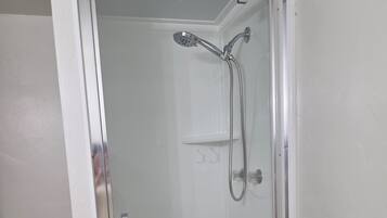 Chuveiro, toalhas de banho, sabonete, papel higiênico
