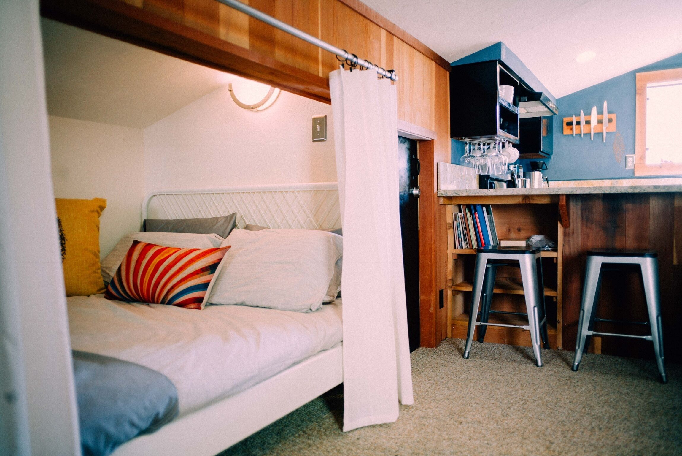 A compact bedroom with a bed, a small desk, and a chair.
