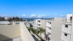 Zona residencial costera con edificios modernos, vistas despejadas al mar y un balcón con vista al océano.