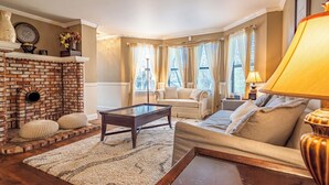 A cozy living room with a brick fireplace, a sofa, a coffee table, and a lamp. - Yosemite+Bass Lake -Hot tub,Game room,BBQ (Oakhurst)