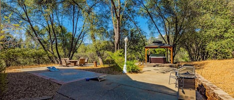 Un patio al aire libre con una parrilla, asientos y un pabellón.